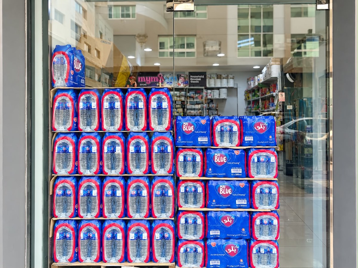 Cases of bottled water stacked in the shopfront window
